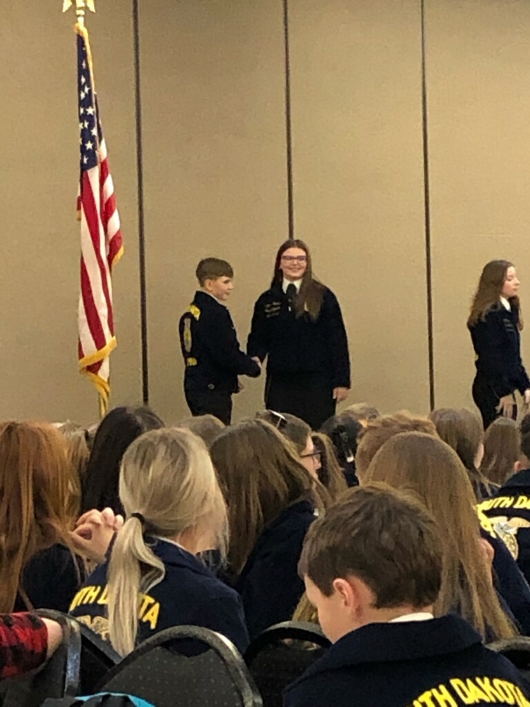 Gage on stage receiving an award from FFA Representative
